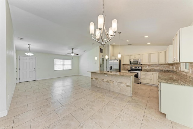 kitchen featuring visible vents, lofted ceiling, appliances with stainless steel finishes, open floor plan, and backsplash