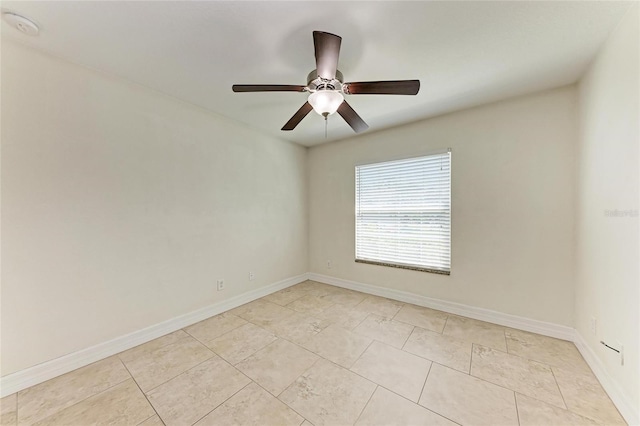 spare room featuring ceiling fan and baseboards