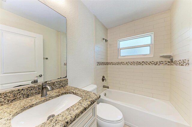 bathroom with bathing tub / shower combination, toilet, and vanity