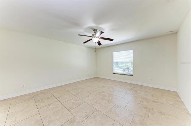 spare room with ceiling fan and baseboards