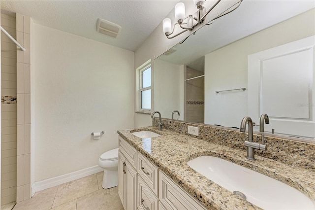 bathroom with a tile shower, tile patterned floors, a sink, and baseboards