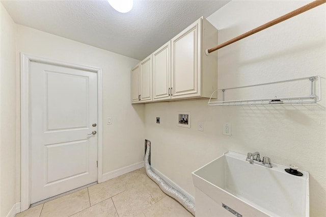 clothes washing area with cabinet space, hookup for a washing machine, hookup for an electric dryer, a textured ceiling, and a sink