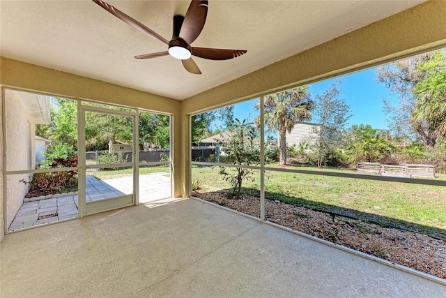 unfurnished sunroom with ceiling fan