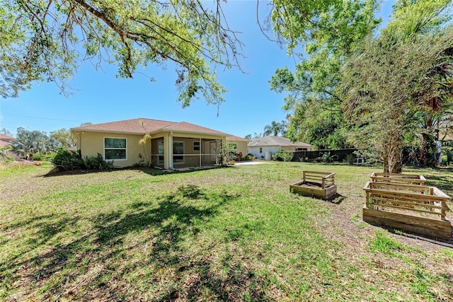 view of yard with a sunroom and a vegetable garden