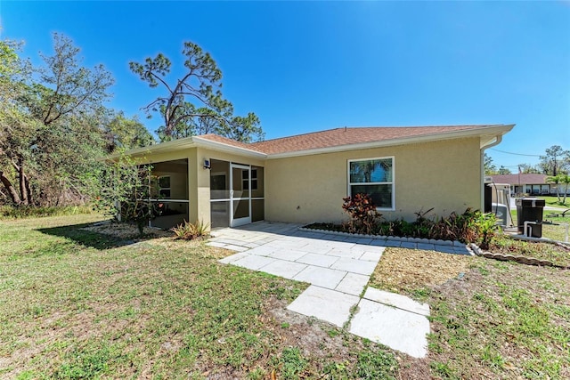 view of front of home featuring a patio area, a front yard, a sunroom, and stucco siding