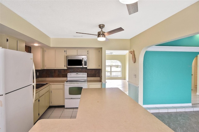 kitchen with ceiling fan, light tile patterned floors, white appliances, light countertops, and cream cabinetry