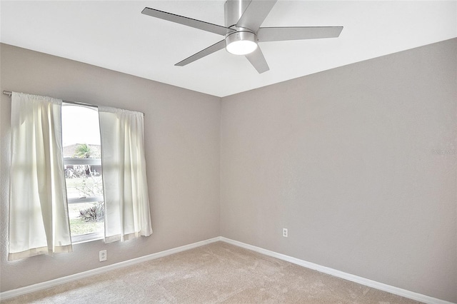 spare room featuring carpet flooring, plenty of natural light, and baseboards