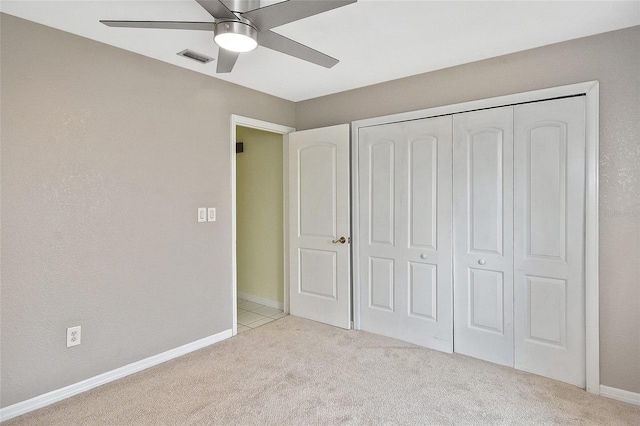 unfurnished bedroom featuring carpet floors, a closet, visible vents, a ceiling fan, and baseboards