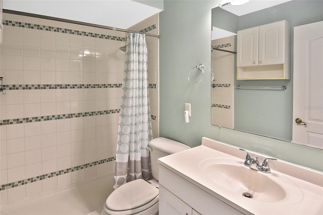 bathroom featuring toilet, tiled shower, and vanity