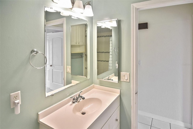 bathroom featuring tile patterned flooring, visible vents, vanity, and baseboards