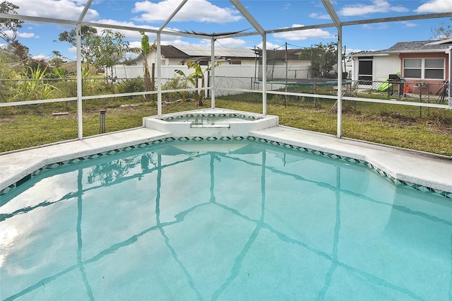 pool featuring an in ground hot tub, fence, and a lanai