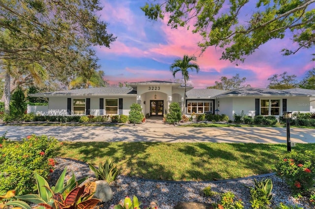 mediterranean / spanish home featuring stucco siding, a front yard, and french doors