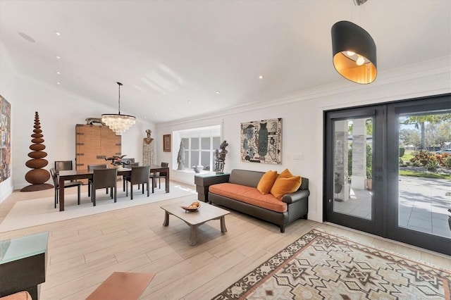 living room featuring a chandelier, vaulted ceiling, french doors, light wood finished floors, and crown molding