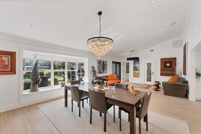 dining area with visible vents, vaulted ceiling, crown molding, light wood-style floors, and a chandelier