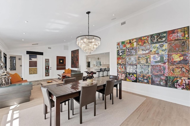 dining space featuring baseboards, visible vents, ornamental molding, wood finished floors, and a notable chandelier