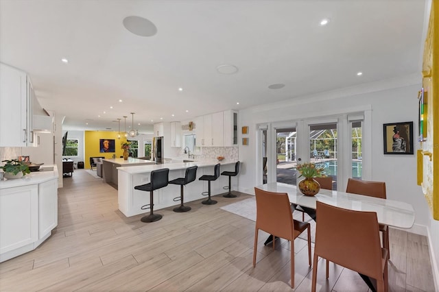 dining room with light wood-type flooring, plenty of natural light, and french doors