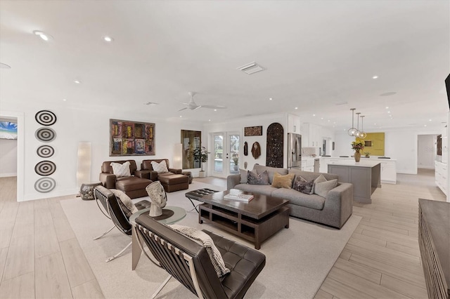 living area featuring light wood finished floors, recessed lighting, visible vents, and french doors