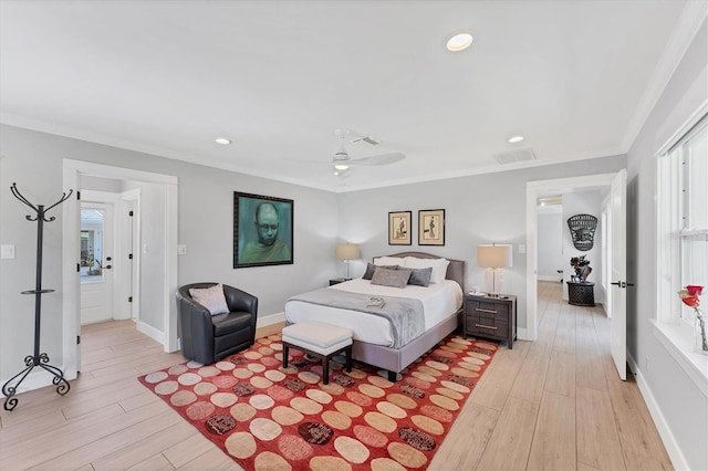 bedroom featuring light wood-type flooring, baseboards, visible vents, and ornamental molding