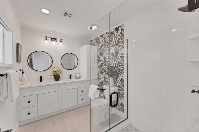 full bath featuring double vanity, tiled shower, a sink, and tile patterned floors