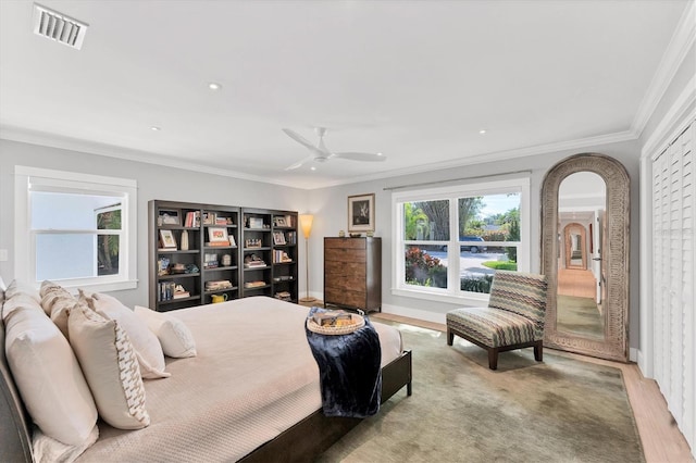 bedroom featuring arched walkways, visible vents, crown molding, and baseboards