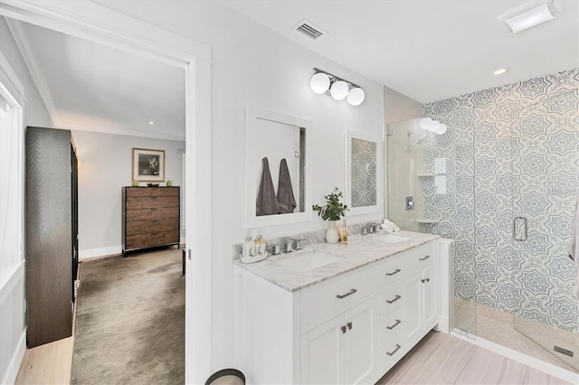 bathroom with a stall shower, visible vents, and a sink