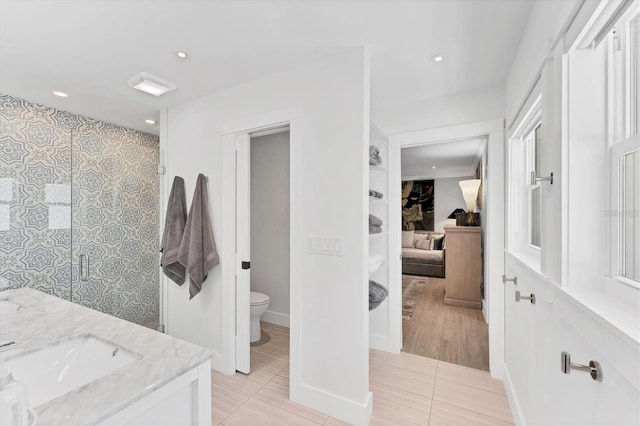 bathroom featuring double vanity, recessed lighting, toilet, connected bathroom, and a sink