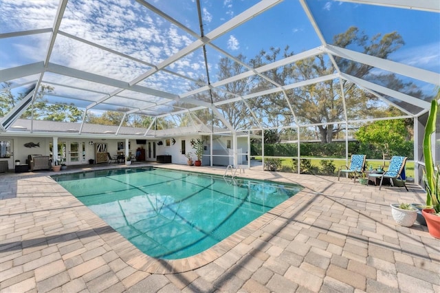 pool featuring glass enclosure and a patio