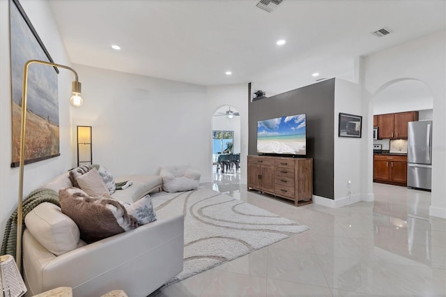 living room with arched walkways, recessed lighting, visible vents, a ceiling fan, and baseboards