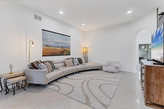 living room with visible vents, arched walkways, baseboards, and recessed lighting