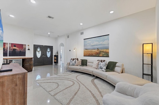 living area featuring arched walkways, visible vents, and recessed lighting