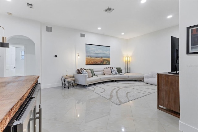 living room featuring visible vents and arched walkways