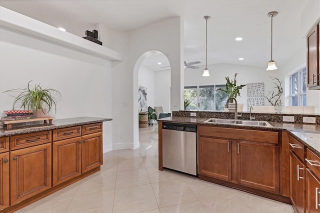 kitchen with plenty of natural light, dark stone counters, dishwasher, hanging light fixtures, and a sink