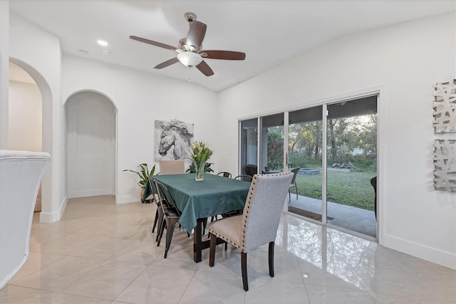 dining room with arched walkways, recessed lighting, a ceiling fan, light tile patterned flooring, and baseboards