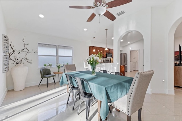 dining room with arched walkways, light tile patterned flooring, visible vents, and recessed lighting