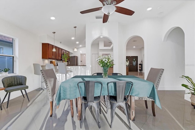 dining room featuring light tile patterned floors, arched walkways, and recessed lighting