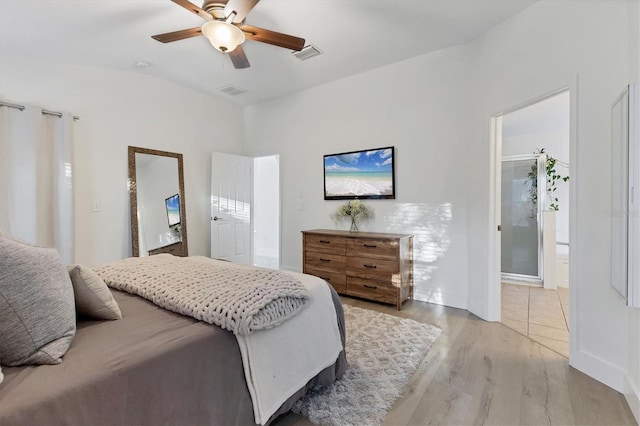 bedroom featuring ensuite bath, light wood finished floors, ceiling fan, and visible vents