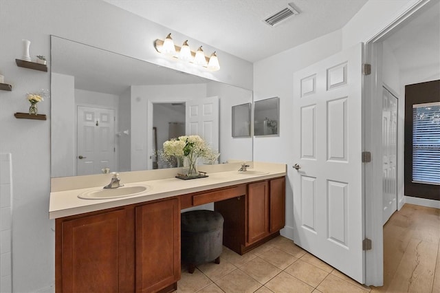 full bath featuring tile patterned floors, visible vents, a sink, and double vanity