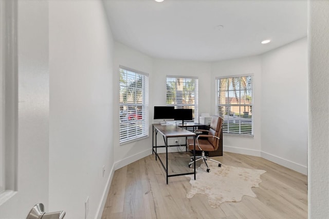 home office featuring wood finished floors, a wealth of natural light, and baseboards