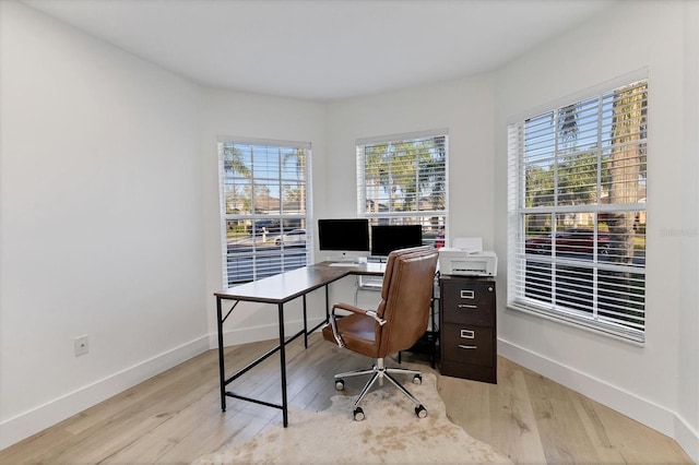 office featuring plenty of natural light, light wood-style flooring, and baseboards