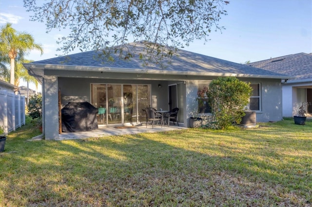 back of house with a patio, fence, roof with shingles, a lawn, and stucco siding