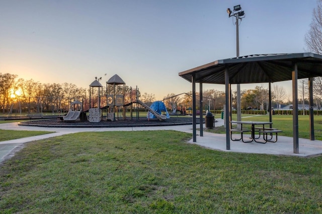 view of property's community with playground community and a yard