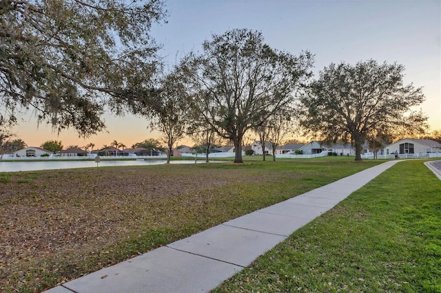 view of home's community with a residential view, a water view, and a lawn