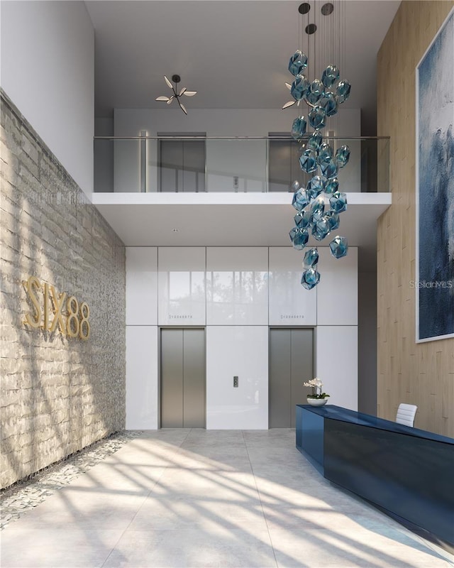 interior space featuring concrete flooring, elevator, and a towering ceiling