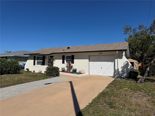 ranch-style home featuring stucco siding, a shingled roof, an attached garage, a front yard, and driveway