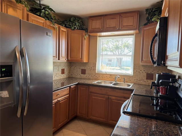 kitchen with black microwave, light tile patterned floors, a sink, stainless steel refrigerator with ice dispenser, and electric range oven