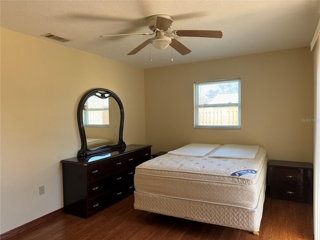 bedroom featuring dark wood-style floors, multiple windows, and visible vents