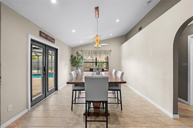 dining space featuring arched walkways, lofted ceiling, recessed lighting, baseboards, and french doors