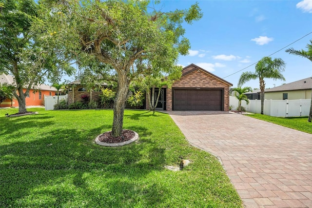 single story home with a garage, fence, decorative driveway, a front lawn, and brick siding