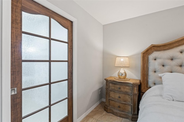 bedroom with light tile patterned floors and baseboards