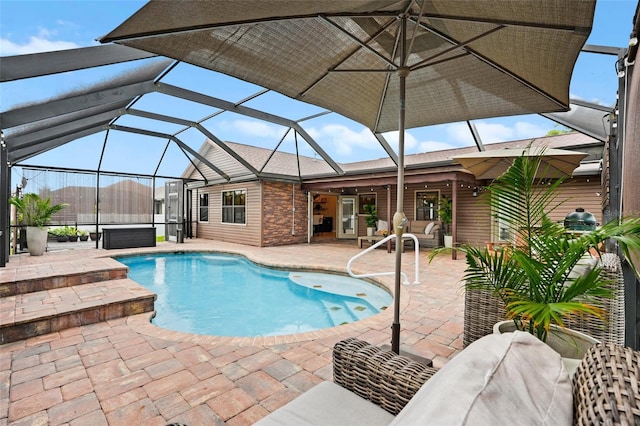 outdoor pool with glass enclosure, a patio area, and a hot tub